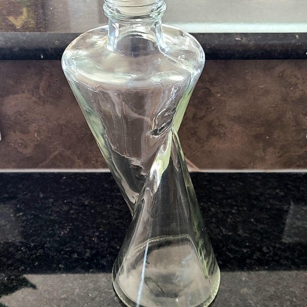 Unusual shape clear glass empty bottle with lid.